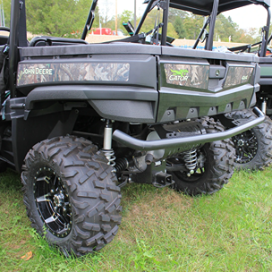 Rear view of camo mid-size crossover utility vehicle showing rugged off-road tires and suspension system outdoors