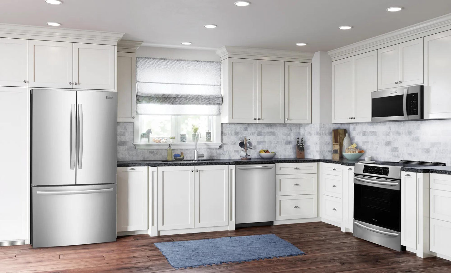 Modern kitchen scene with stainless steel appliances including over-the-range microwave and hardwood floor