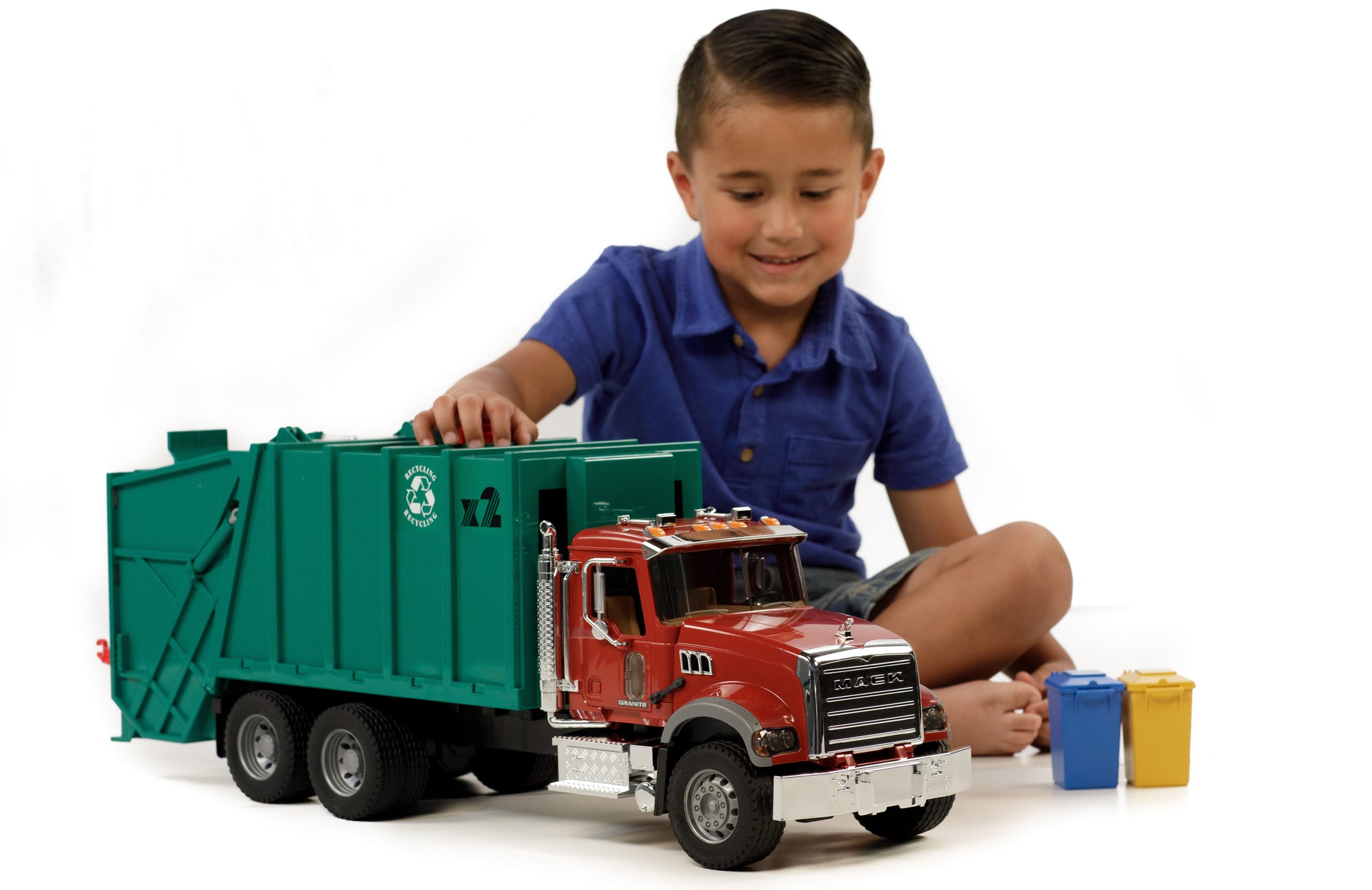 Young boy playing with Bruder Toys 1:16 scale Mack Granite garbage truck and small recycling bins in Toys & Games collection