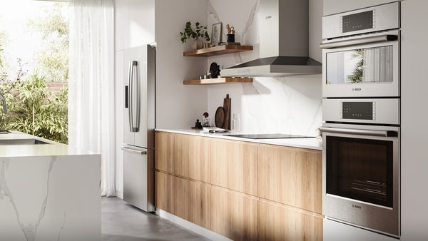 Modern kitchen featuring built-in stainless steel induction cooktop and double wall ovens with wood cabinetry and open shelving