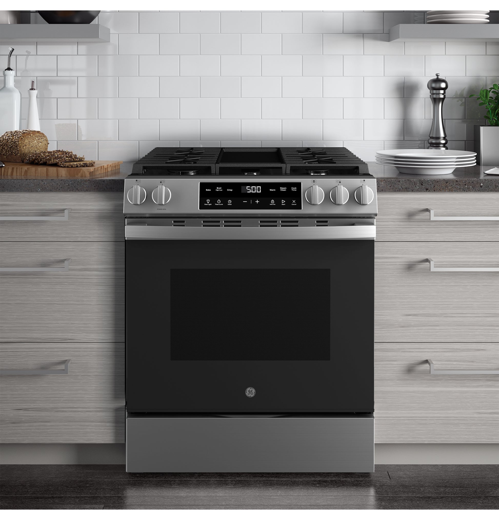 Slide-in stainless steel front control gas range with digital display and knob controls in modern kitchen setting