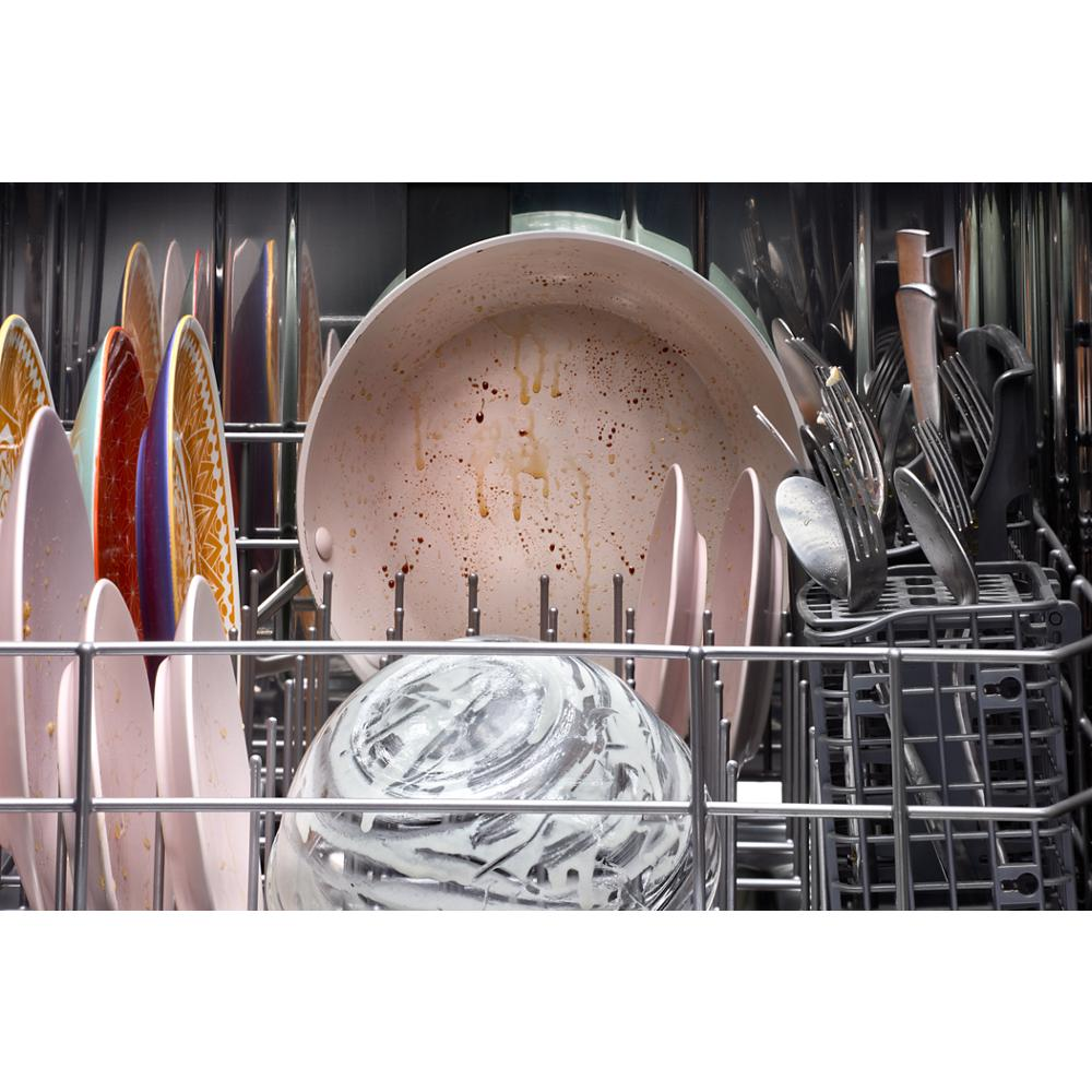 Close-up of soiled dishes, utensils, and cookware loaded inside a dishwasher from kitchenware and appliances collection