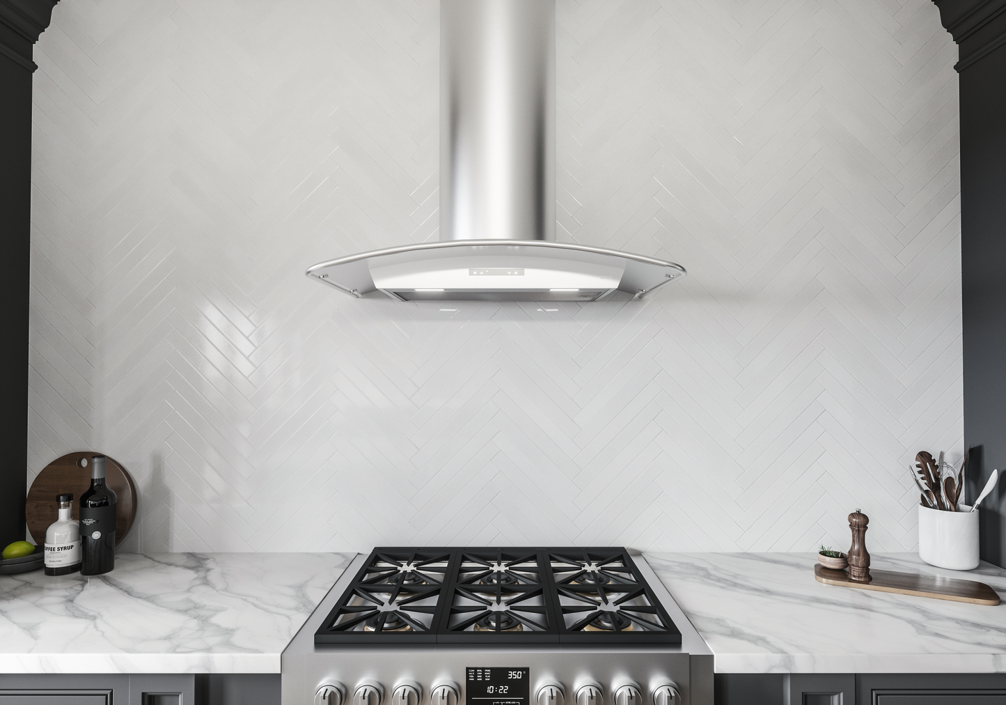 Stainless steel chimney hood with curved glass canopy and LED lighting above a gas cooktop in modern kitchen setting