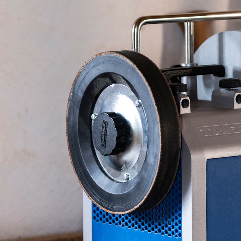 Leather honing wheel with metal plate and adjustment knob mounted on sharpening machine for home improvement tools use