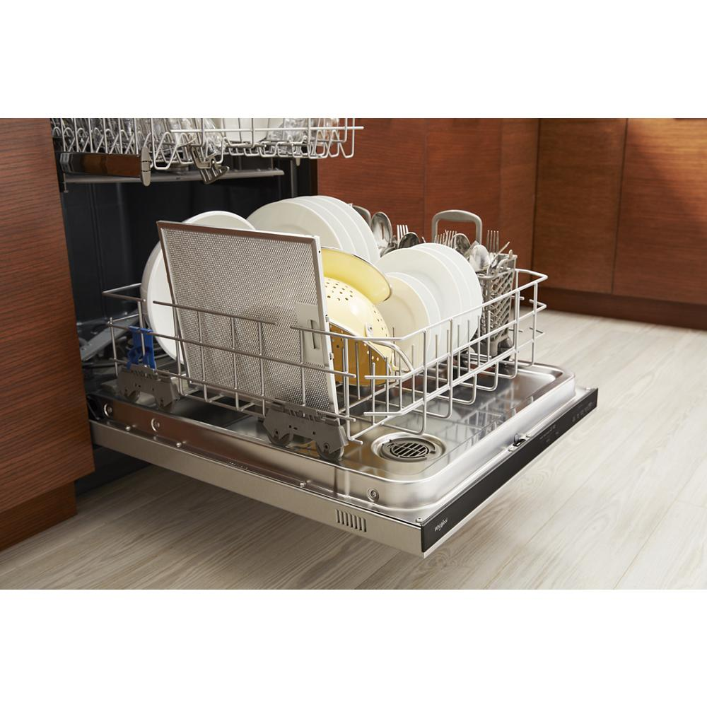 Stainless steel dishwasher drawer open with clean white plates, colander, and cutlery inside in modern kitchen