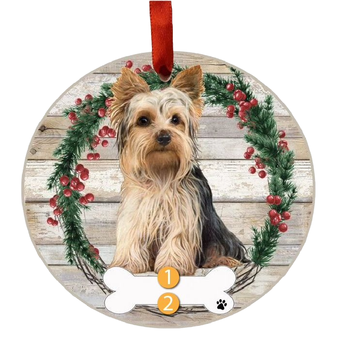 Round Christmas ornament featuring a Yorkie inside a festive holly wreath with a red ribbon hanger