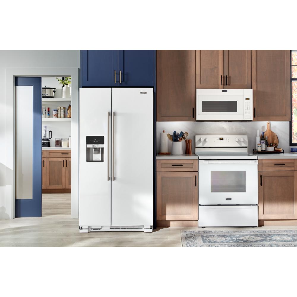 White side-by-side refrigerator with water and ice dispenser installed in modern kitchen with wood cabinets and appliances