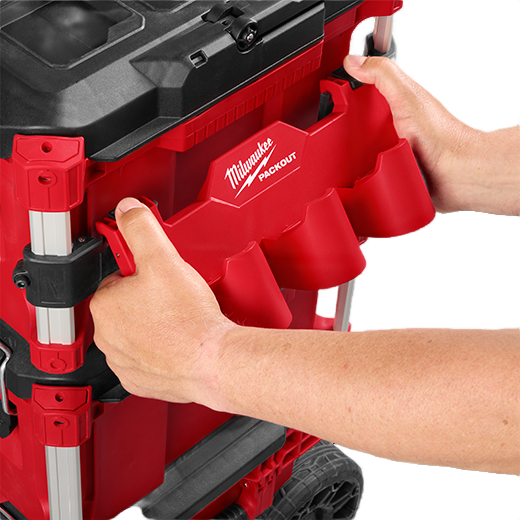 Hands attaching red Milwaukee battery rack for M12 batteries to tool storage system in workshop organization setting
