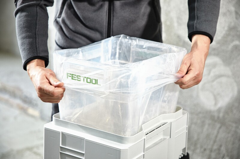 Person installing a clear disposable dust liner into a CT CYCLONE collection bin for woodworking dust management