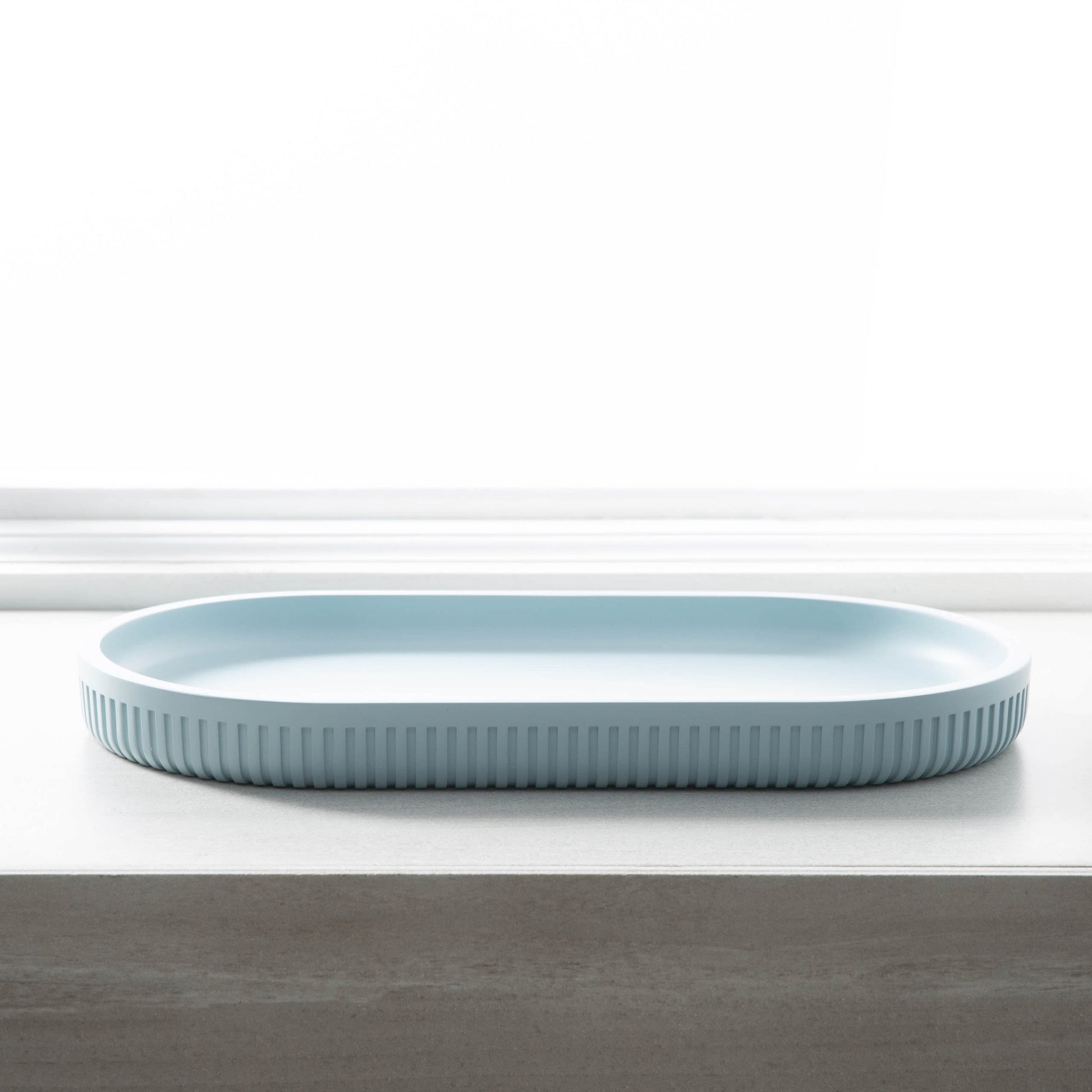 Light blue oval serving tray with textured edges, ideal for stylish home organization and decor displays