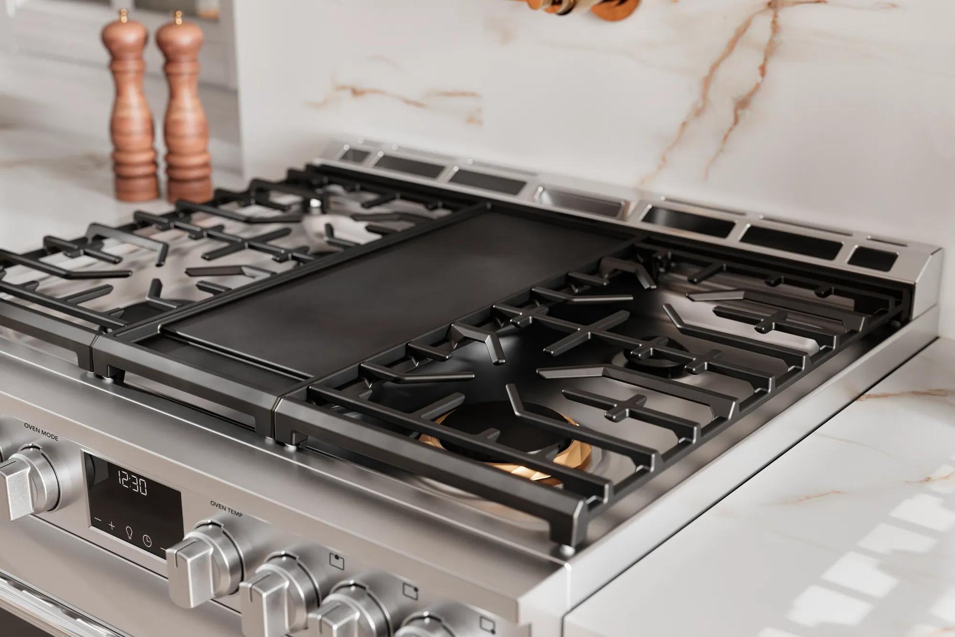 Close-up of stainless steel gas range cooktop with griddle and cast iron grates in Ranges and Kitchen & Kitchenware collections