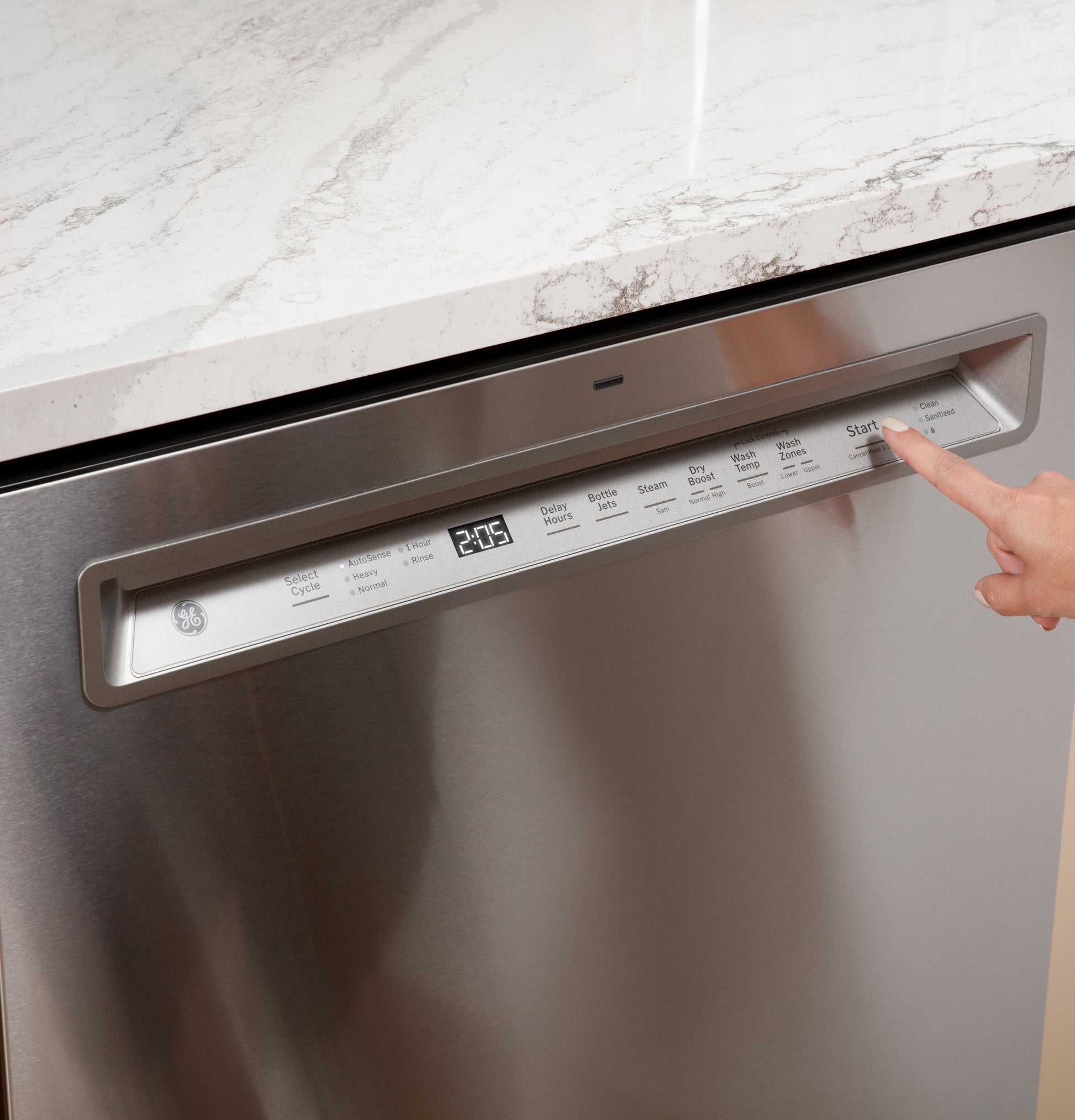 Close-up of stainless steel dishwasher front control panel with digital display and a finger pressing the start button