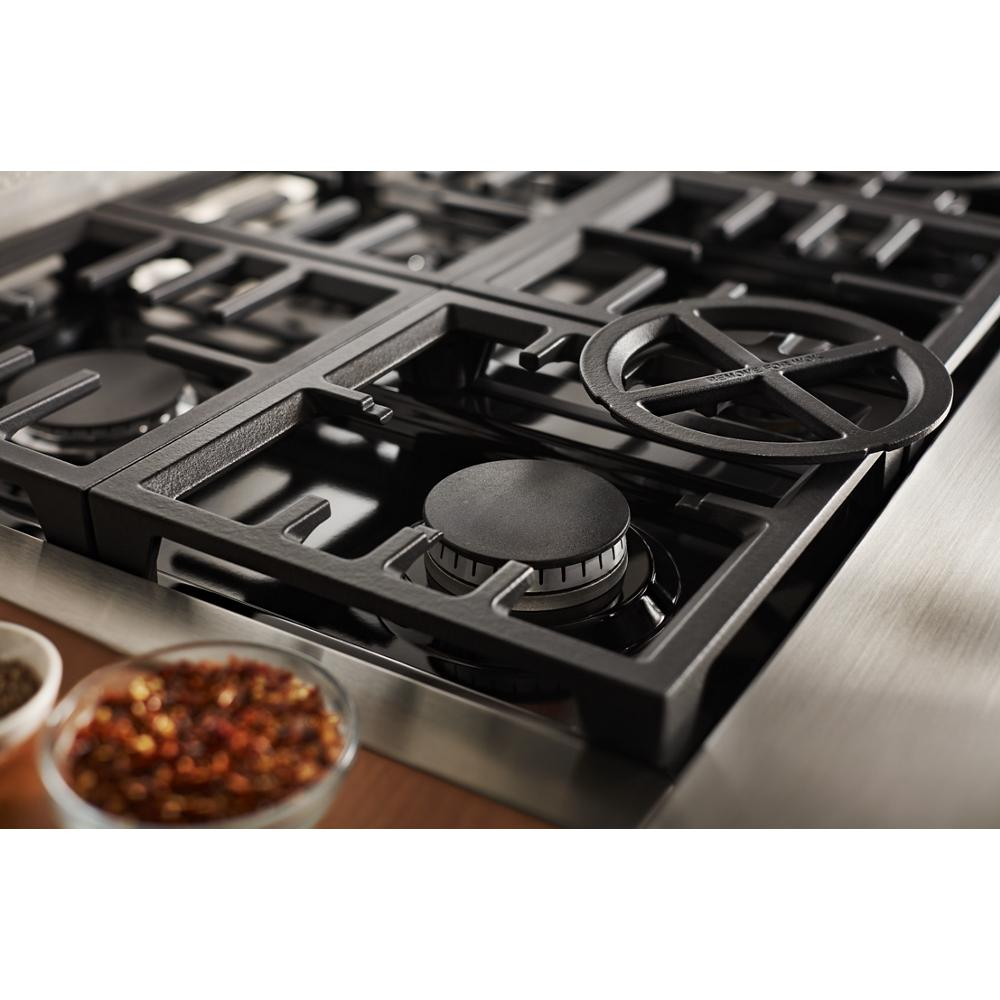 Close-up of black cast iron grates and burner on stainless steel dual fuel cooktop in KitchenAid range from Ranges & Kitchenware collection