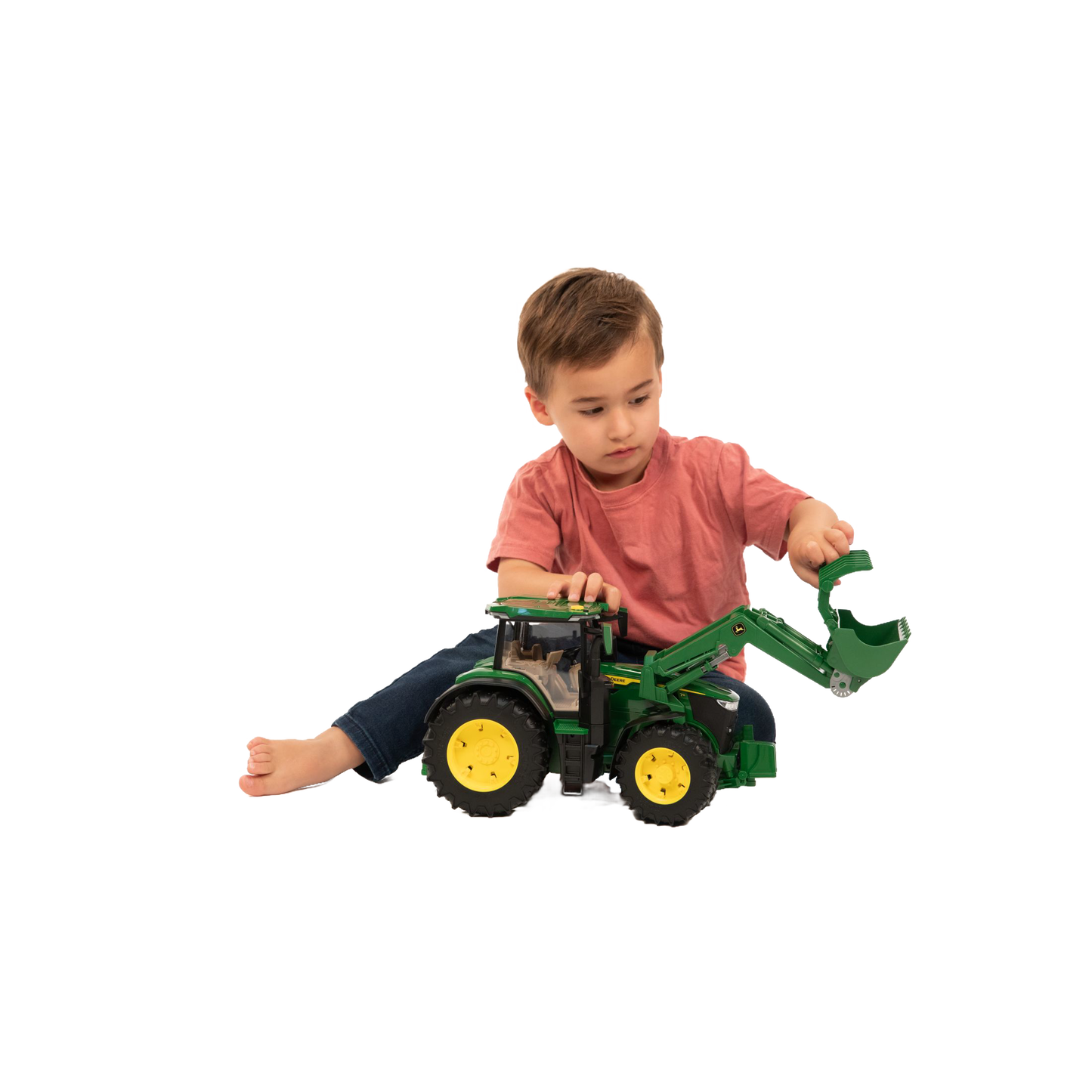 Young child playing with green and yellow toy tractor with front loader from Vehicles & Remote Controlled Toys collection