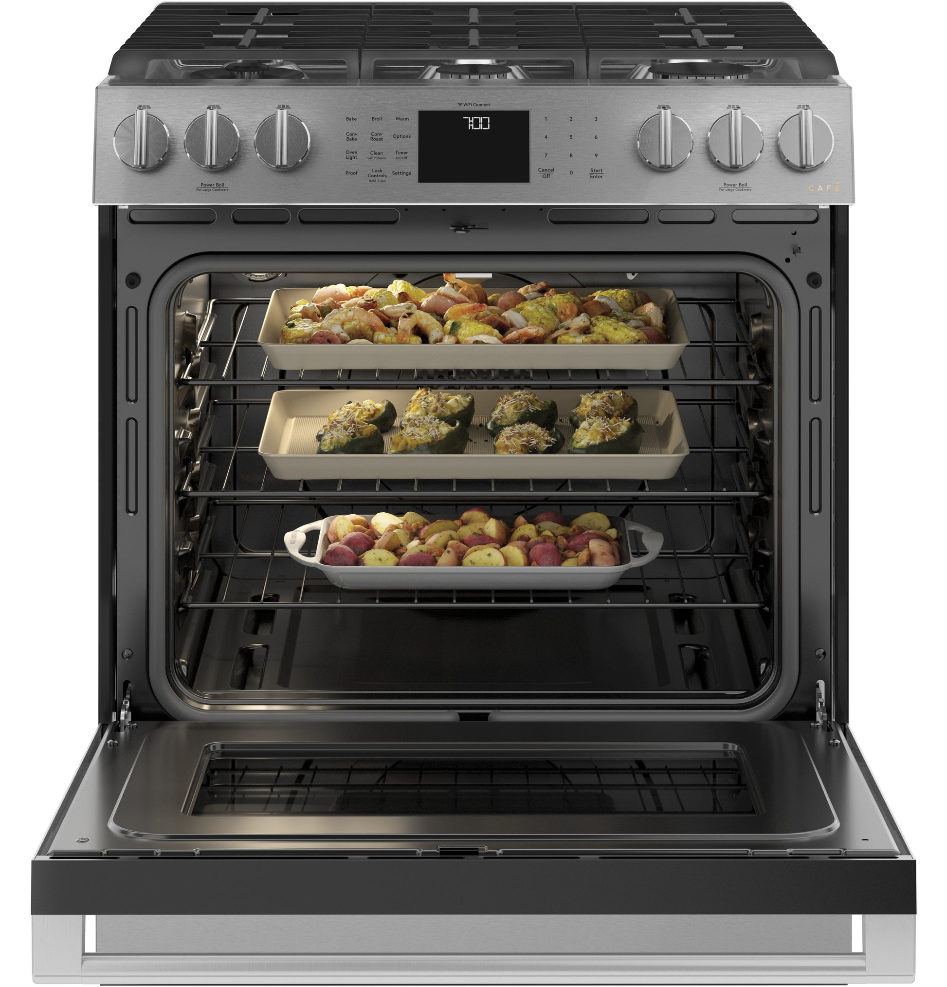 Open front-control gas range in platinum glass with convection oven and three racks of roasting trays cooking vegetables