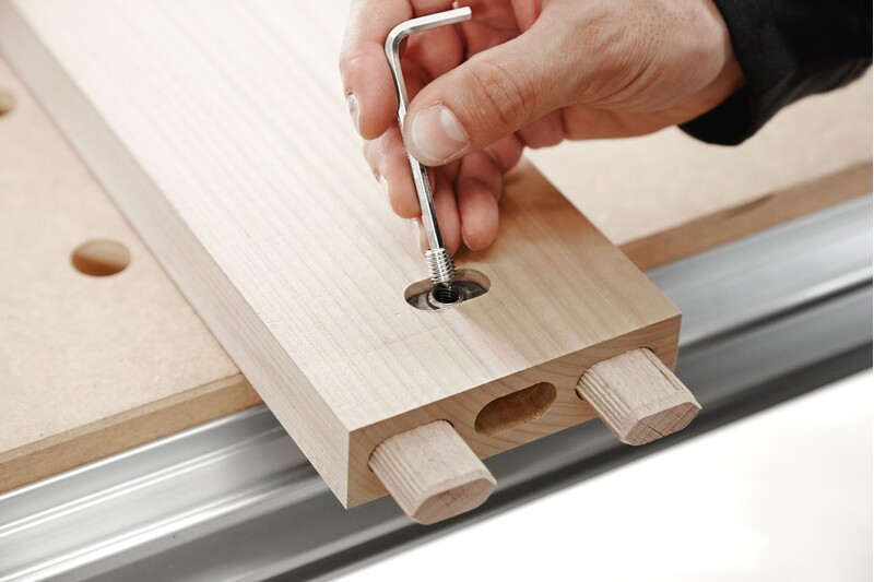 Hand tightening screw anchor with Allen wrench into wooden joinery piece for woodworking tool accessories collection