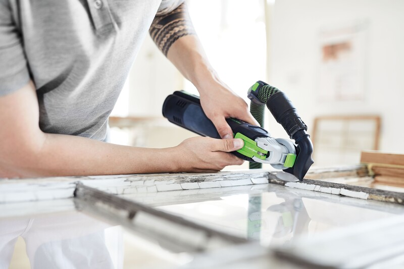 Person using a Festool oscillating multi-tool with 18 segment saw blade to remove window glazing in woodworking tool accessories