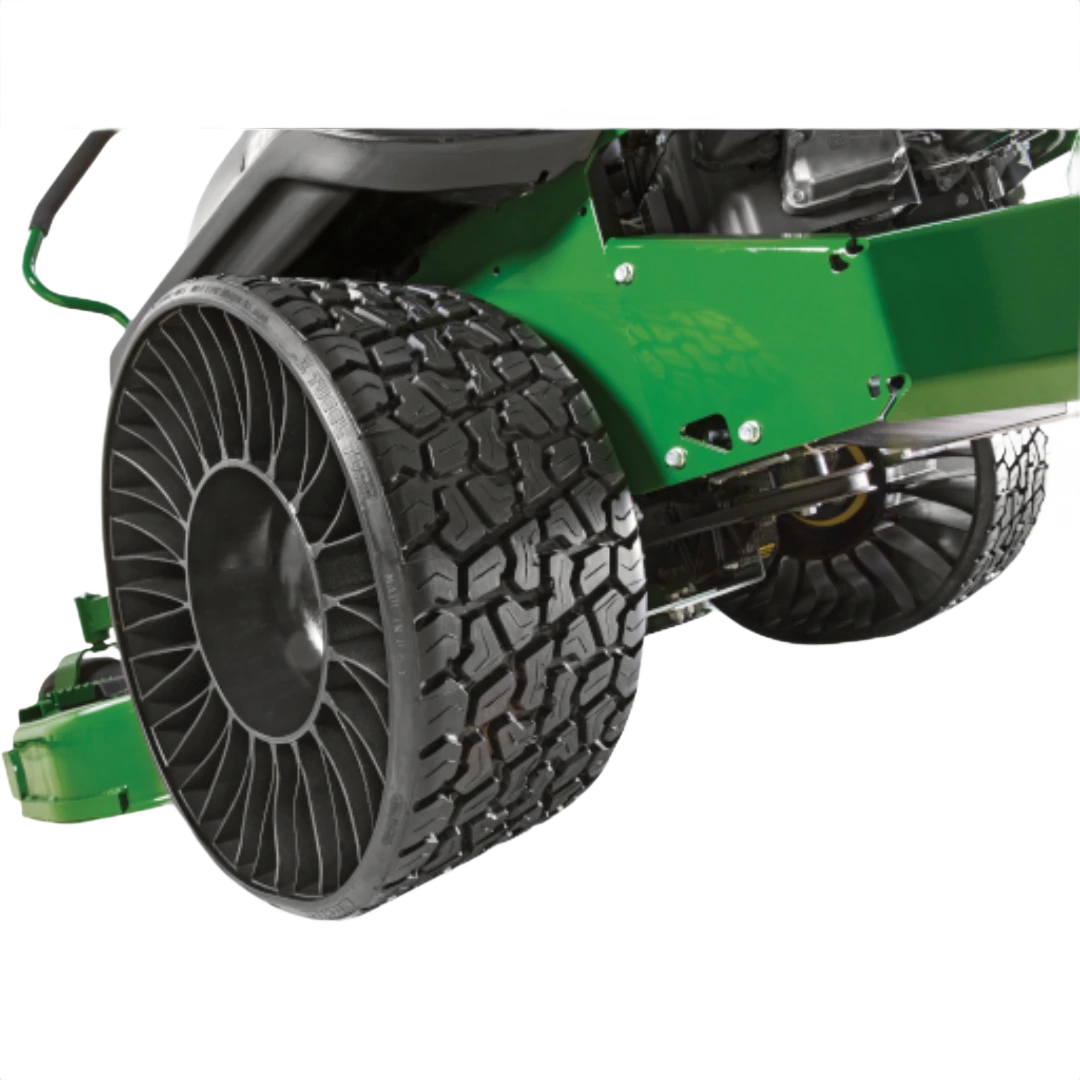 Close-up of large uninflated Tweel tire on green zero-turn mower deck for home improvement tasks