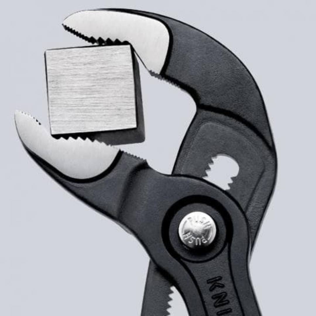 Close-up of adjustable black pliers gripping a metal square block, suitable for woodworking and home improvement tools