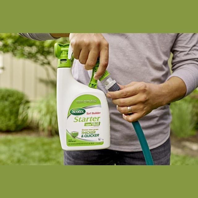 Person attaching Scotts Turf Builder Starter Food spray bottle to garden hose in lawn care and fertilizer setting