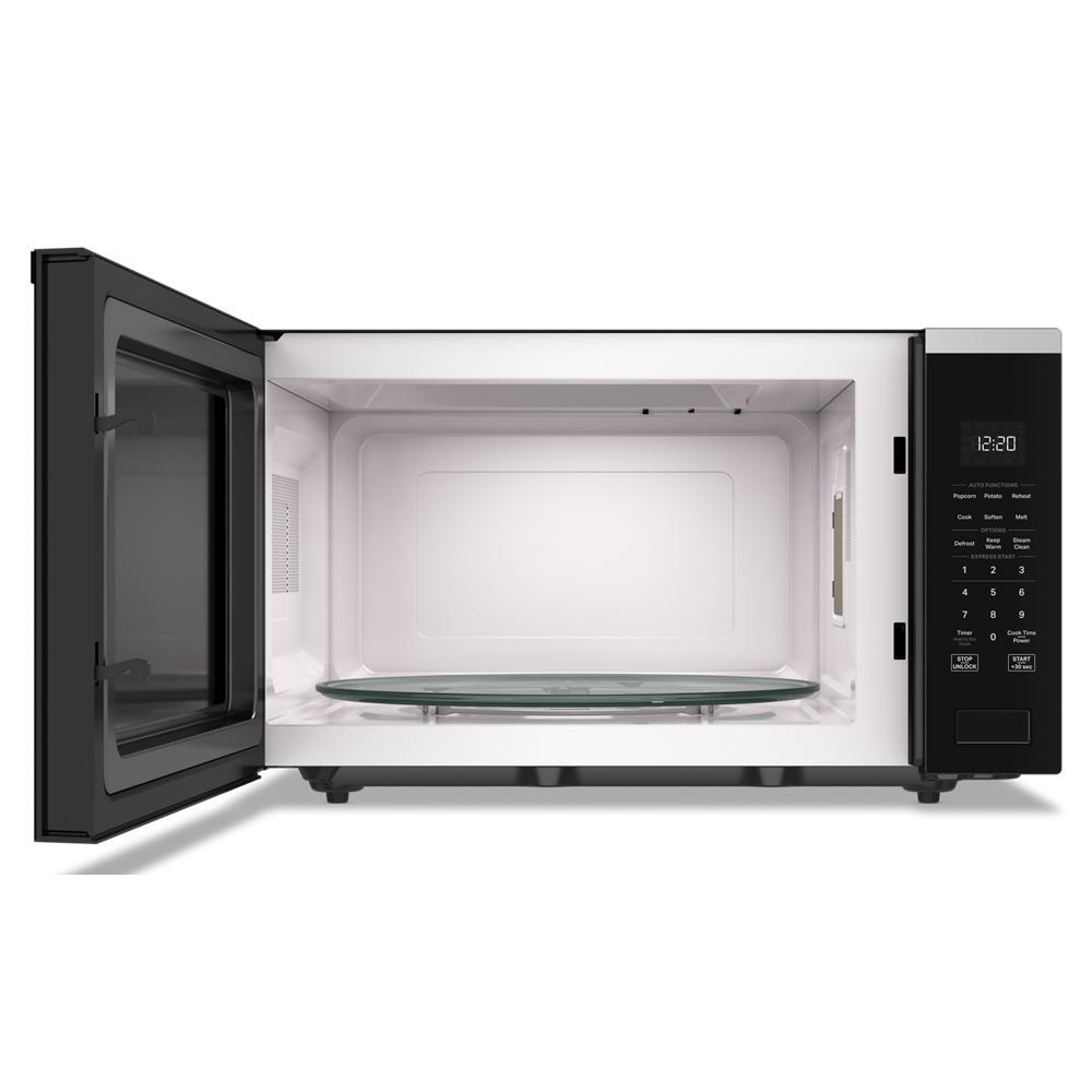 Open black Whirlpool microwave with sensor cooking and digital control panel in kitchen appliances collection