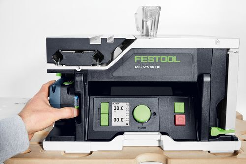 Hand adjusting settings on a compact Festool cordless table saw designed for portable precision in power tools collection