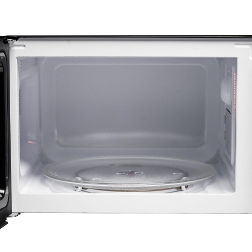 Interior view of countertop microwave featuring glass turntable and clean white cavity for kitchen appliances use
