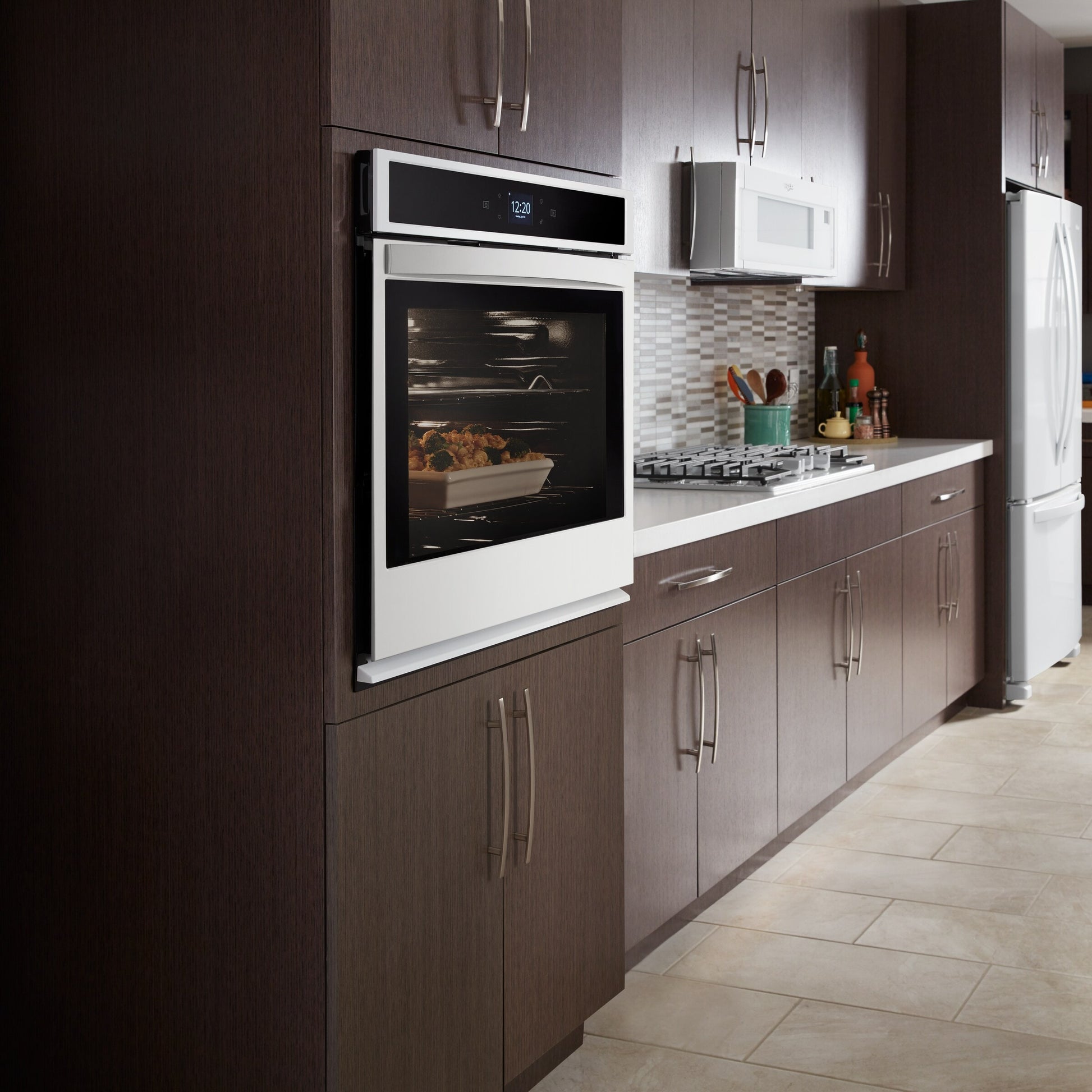 Built-in oven with glass door and digital display built into dark wood cabinetry in modern kitchen appliances setting