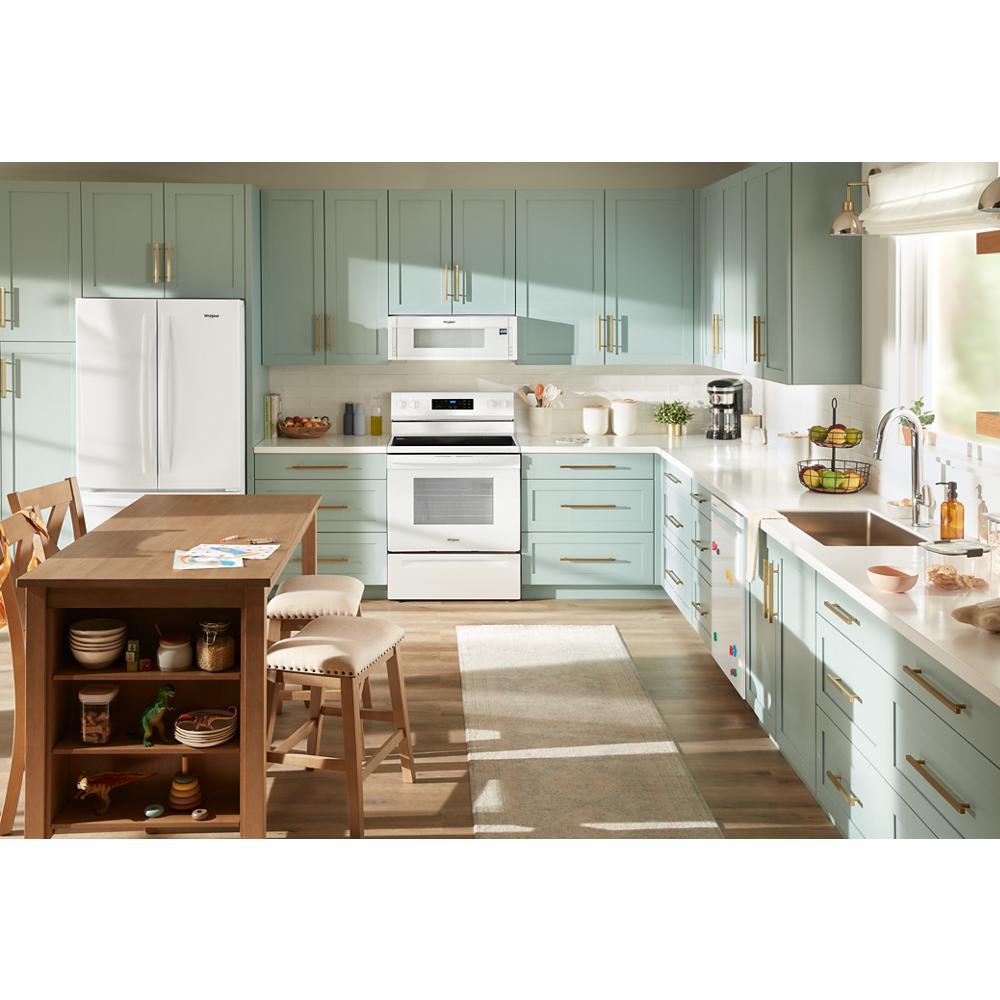 Kitchen with light green cabinets, white low profile microwave hood combination, white appliances, and natural wood island with stools