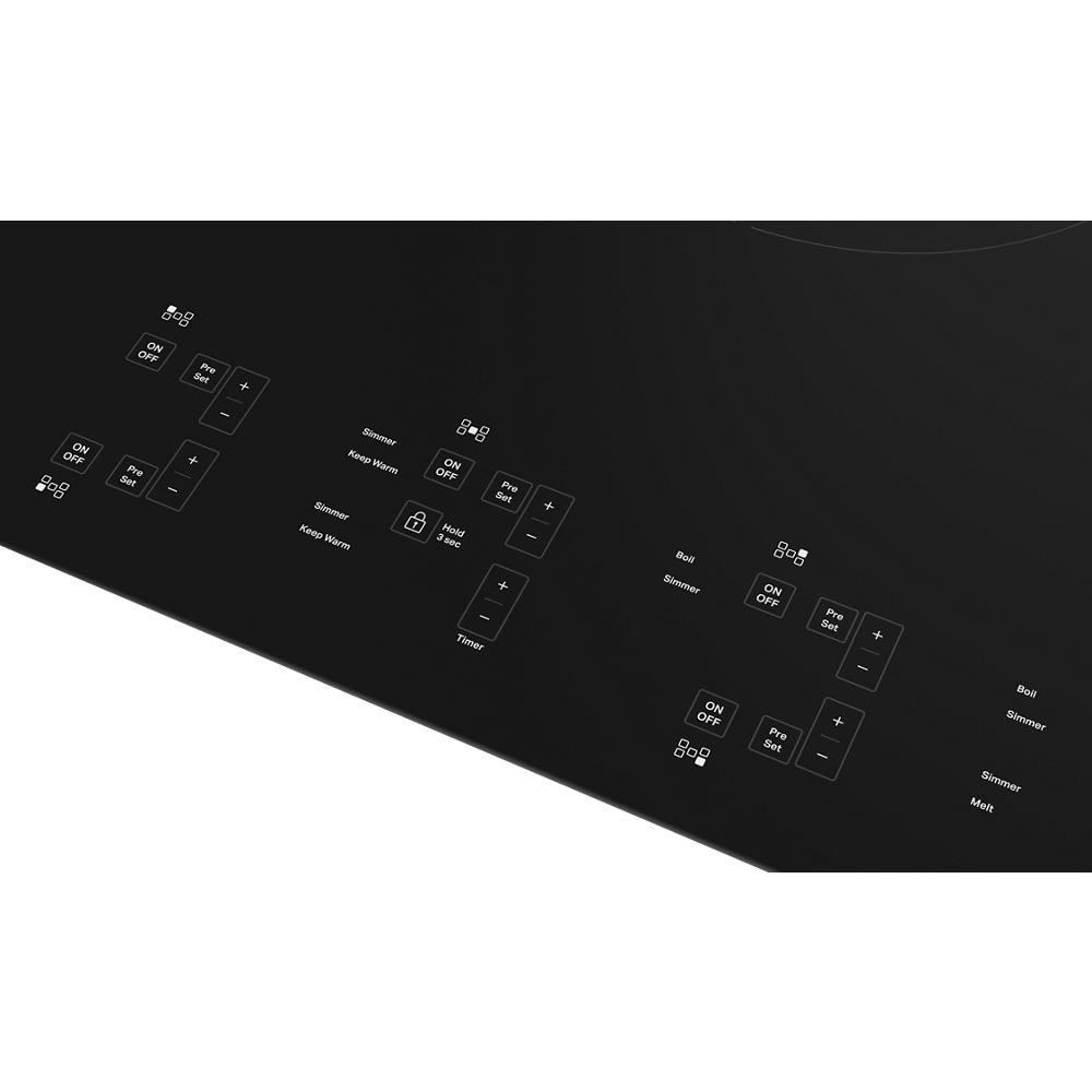 Close-up of black induction cooktop touch controls with five sensor-activated cooking elements in modern kitchenware collection