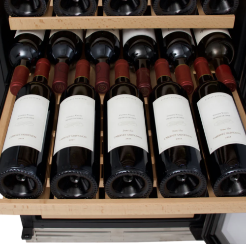 Wooden shelves inside a designer wine cooler holding multiple bottles of red wine in kitchen appliances collection