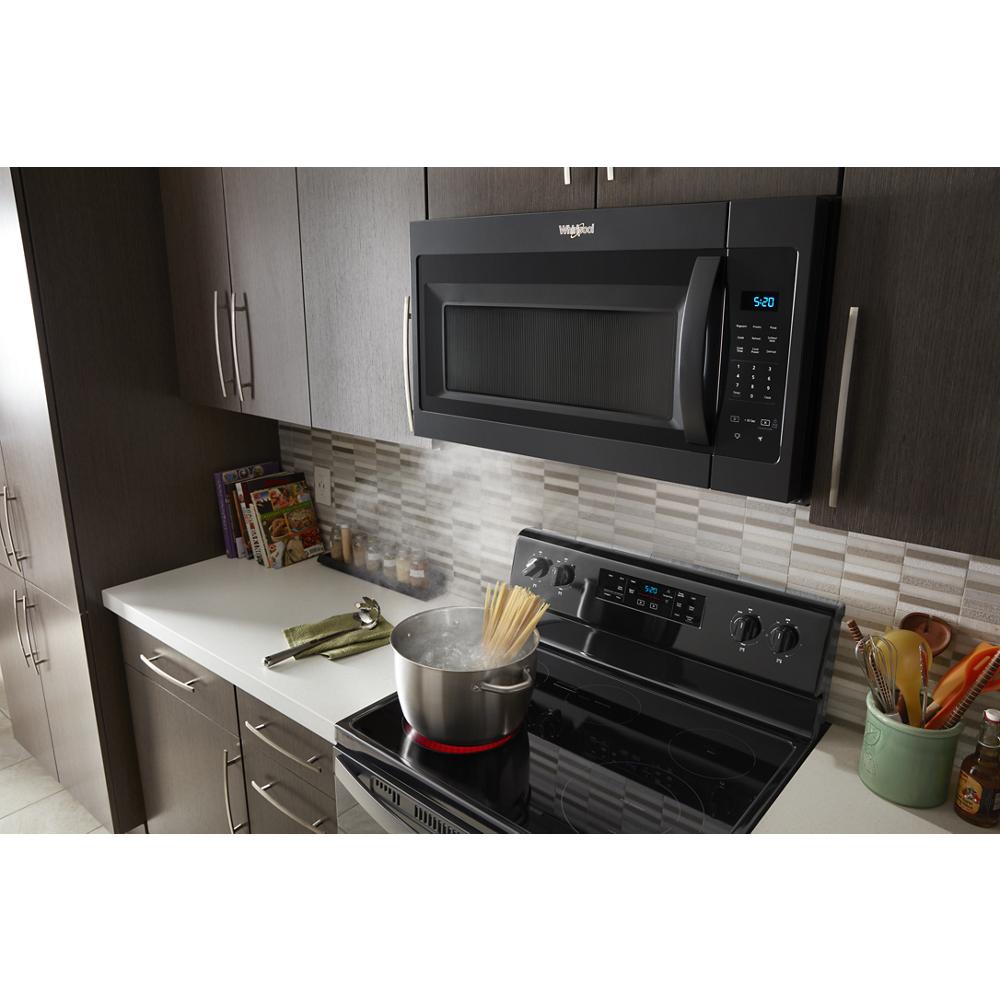 Black Whirlpool microwave with electronic touch controls installed above electric stove in modern kitchen setting