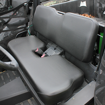Black vinyl bench seat with seatbelts inside a John Deere crossover utility vehicle cabin