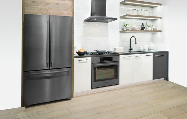 Modern kitchen featuring black stainless steel refrigerator, wall hood, and stove with white cabinetry and open shelving
