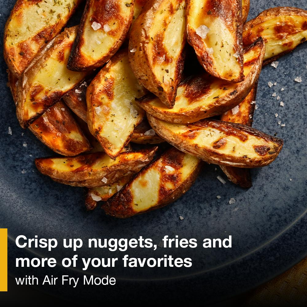 Golden-brown air fried potato wedges seasoned with coarse salt on a dark blue plate for kitchenware collection