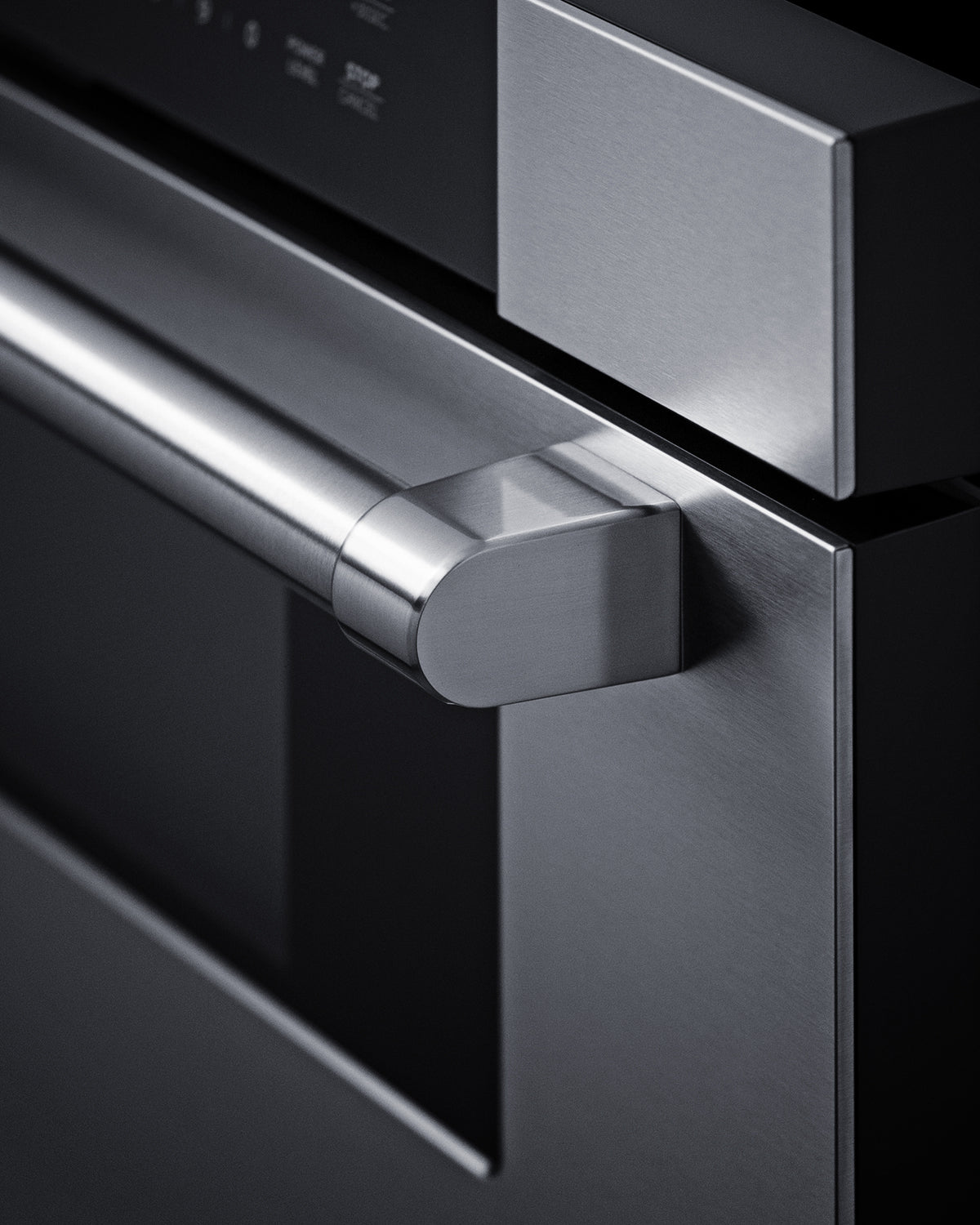 Close-up of stainless steel handle and control panel on built-in drawer microwave in modern kitchen appliance collection