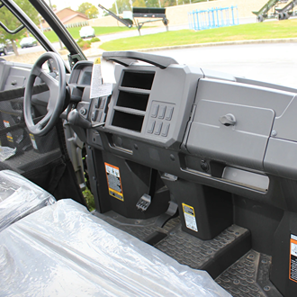 Interior view of a utility vehicle dashboard with multiple compartments and protective seat covers visible
