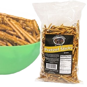 Clear bag of classic pretzel sticks with a green bowl of snacks from Chips & Snacks collection