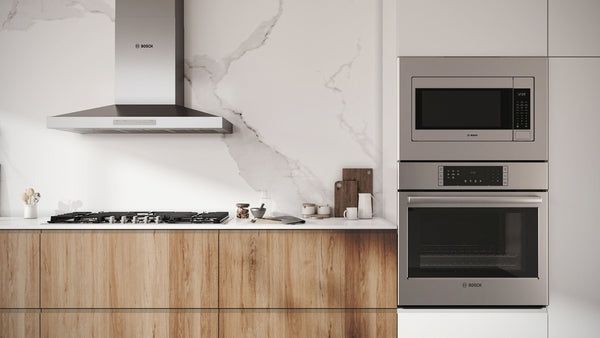 Built-in stainless steel microwave with left side-opening door and digital controls in modern kitchen setting