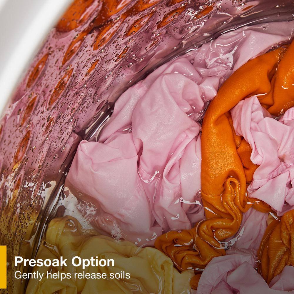 Close-up of colorful clothing soaking during presoak cycle inside a Whirlpool top load washer drum.