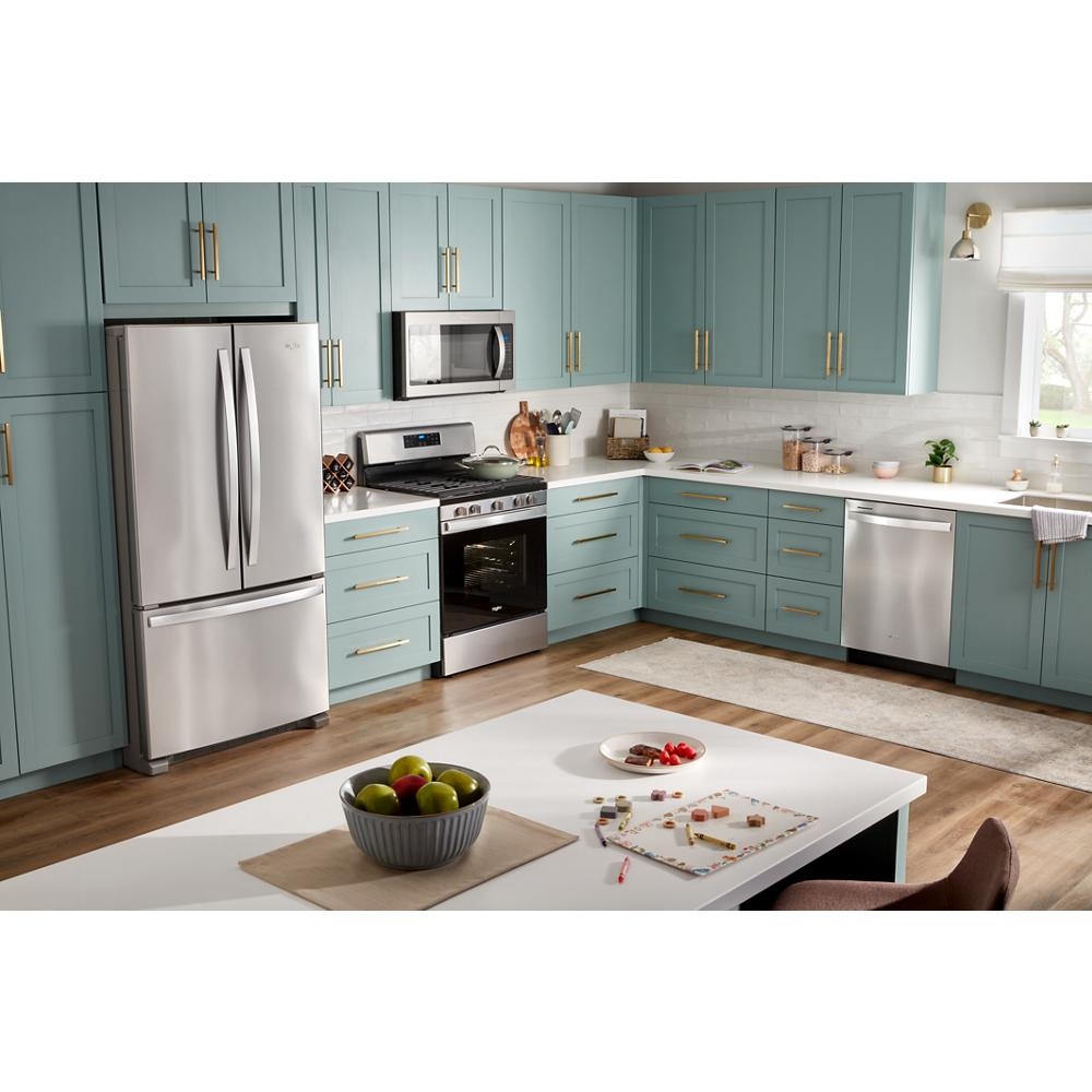 Modern kitchen with stainless steel appliances including over the range microwave, refrigerator, stove, and dishwasher