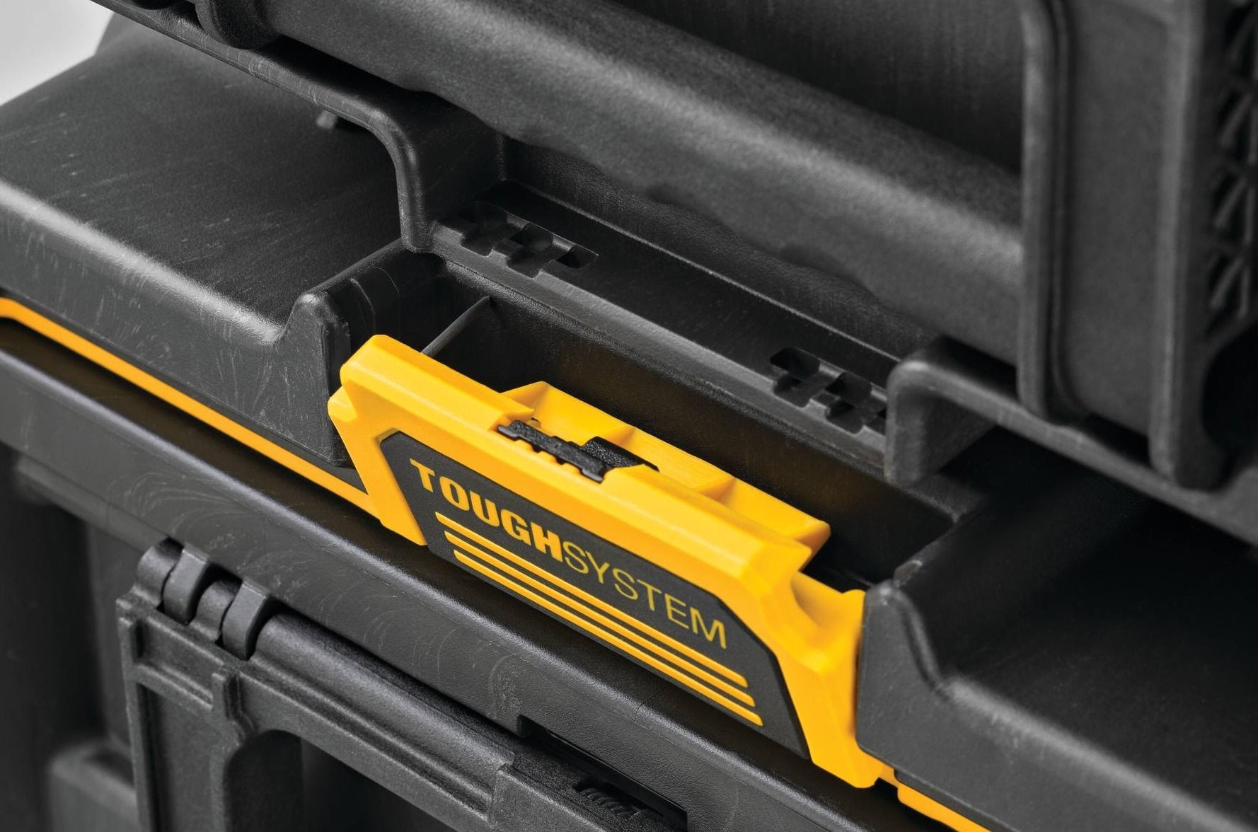 Close-up of yellow and black interlocking latch on durable storage system for jobsite and workshop tool organization