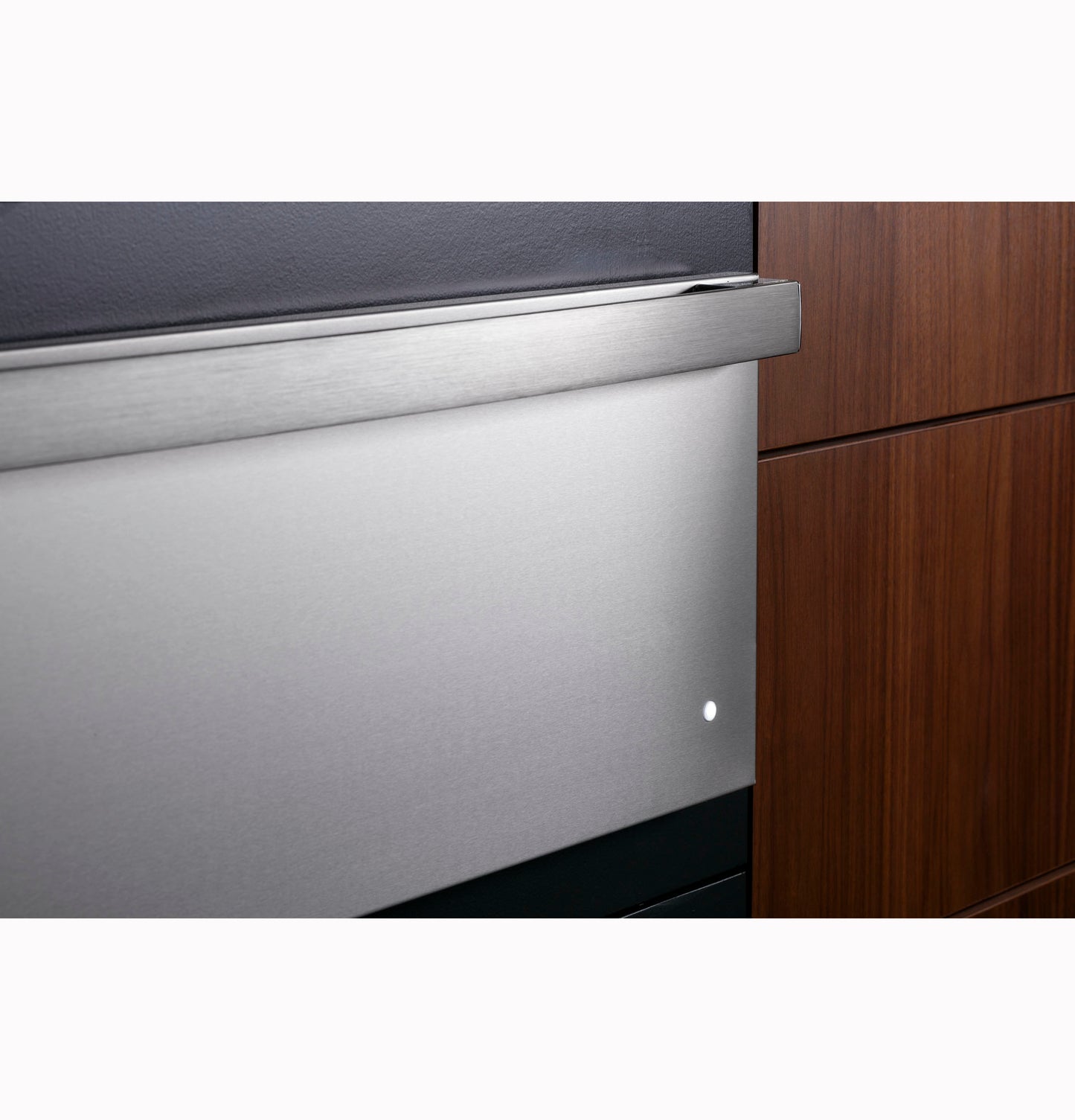 Close-up of a stainless steel warming drawer integrated into modern kitchen cabinetry with wood finishes.