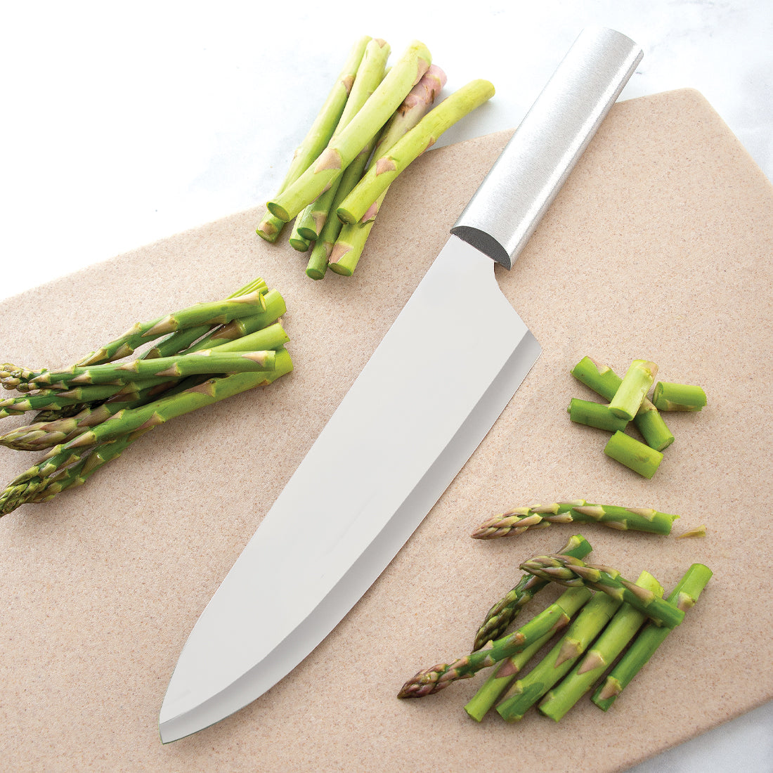 Sleek kitchen knife with polished steel blade and handle on cutting board with fresh asparagus in kitchenware collections