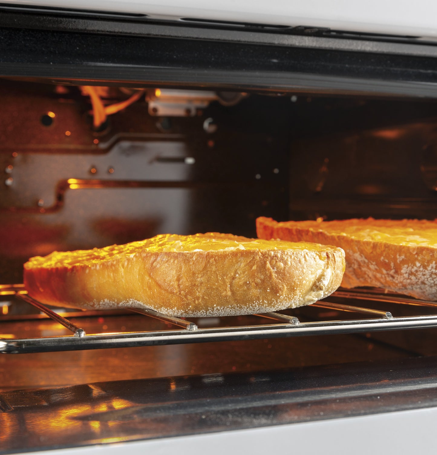 Two pies baking inside the oven of a front-control free-standing gas range in a modern kitchen setting