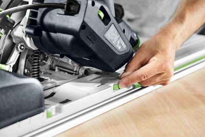 Hand adjusting green lever on Festool plunge cut track saw along 75-inch guide rail for precise home improvement cuts