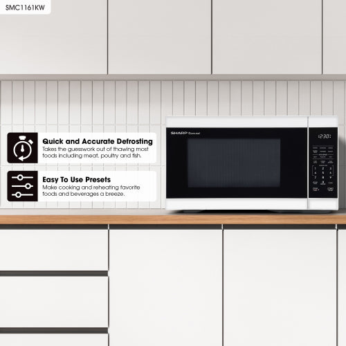 White countertop microwave oven with digital control panel sitting on wooden surface in kitchen appliances collection