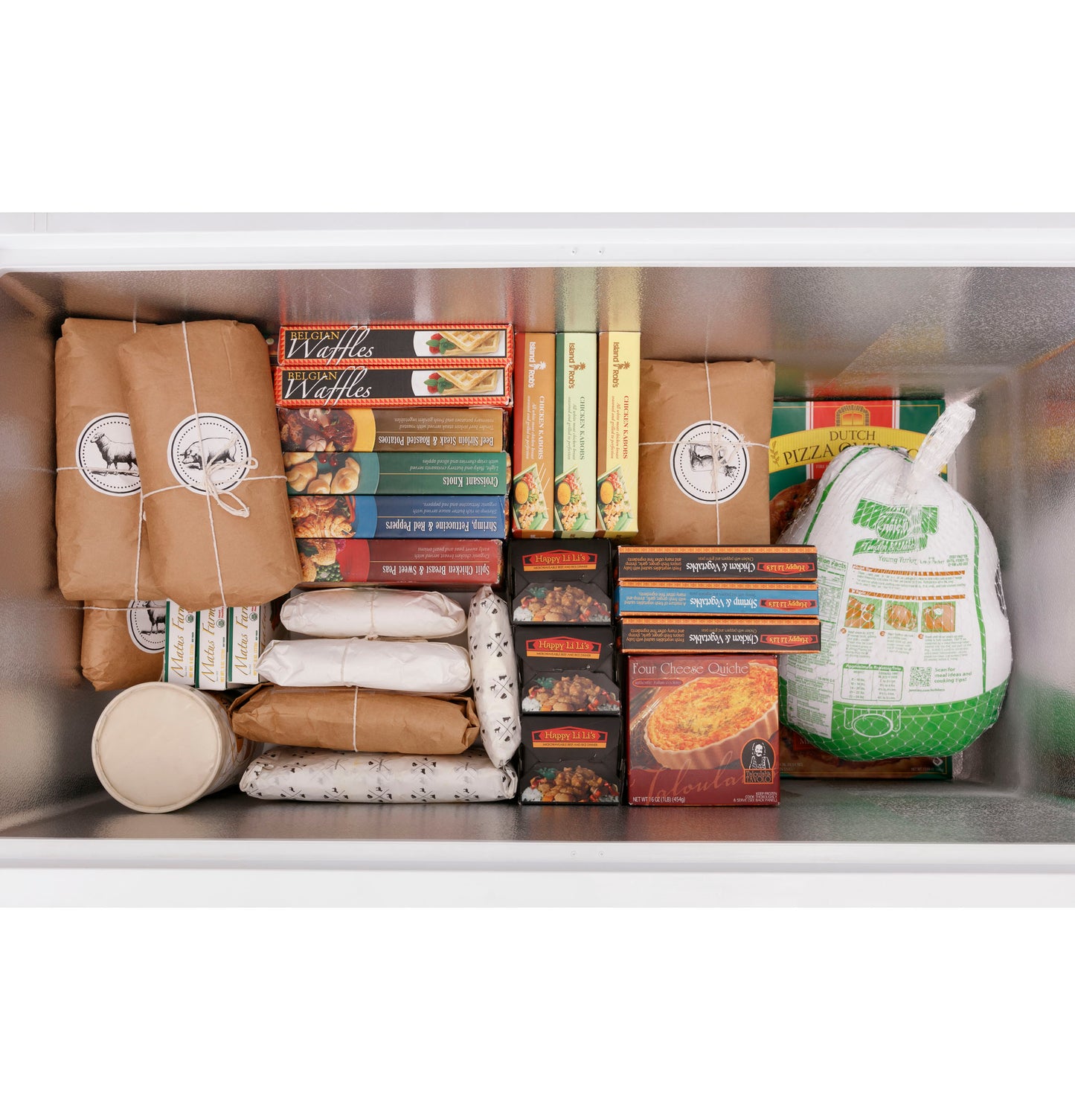 Top-down view of loaded chest freezer with wrapped meats, frozen pastries, and packaged frozen foods inside white compartment