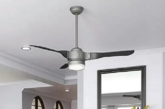 Contemporary ceiling fan with three sleek black blades and integrated light fixture mounted on a white ceiling in a modern interior space.