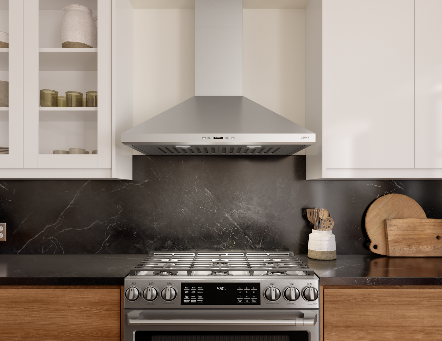 Stainless steel wall mounted range hood with LED lights and digital display above a gas stove in kitchen appliances collection